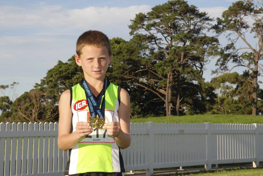 Taj Ford shows off the gold medals he won at the NSW Little Athletics State Championships in the under-10s 800-metre and 1500- metre events. Picture: PHIL McCARROLL