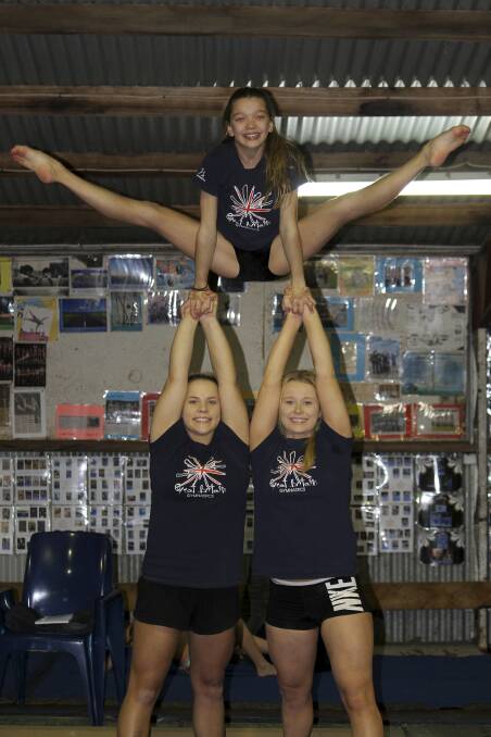 Oak Flats Albion Park Gymnastics and Acrobatics Club's Jessica Adams (top), Mikayla Stephens and Maddison Lacey in action at training last week. Picture: DAVID HALL