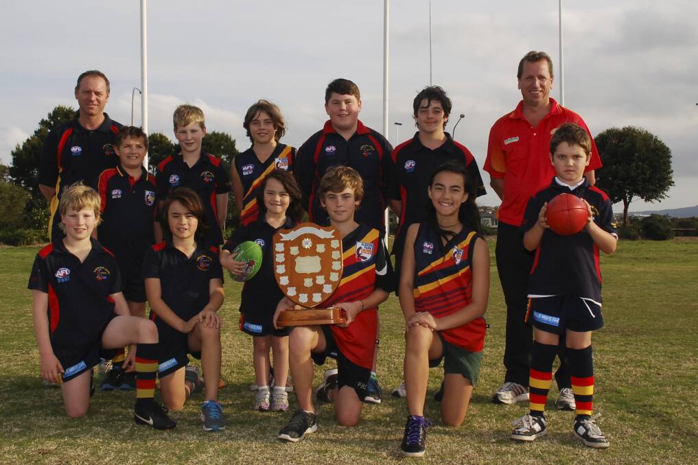 Albion Park Crows president Alan Cooper, Connor Murada, Jack Grant, Miles Dent, John Fitzgerald, Jacob Martins, Shellharbour Swans president Marcus Hollingsworth, (front) Liam Grant, Brendan Cooper, Mia Cooper, Isaac Fitzgerald, Serena Cooper and Ethan Bubas with their Graeme Wells Development Award. Picture: DAVID HALL