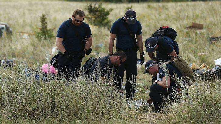 Australian Federal Police officers and their Dutch counterparts collect human remains from the MH17 crash site in the fields outside the village of Grabovka in eastern Ukraine. Photo: Kate Geraghty