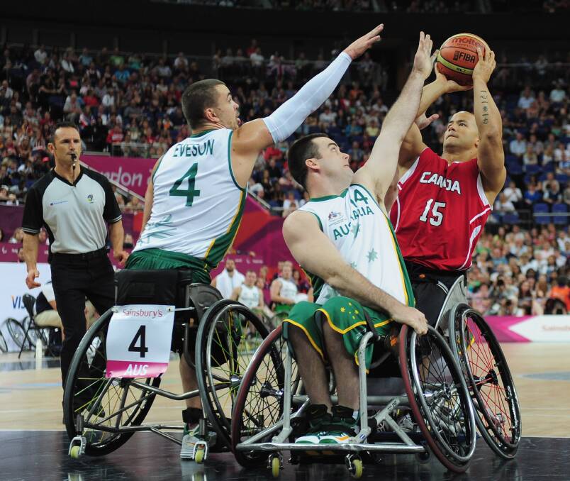 David Eng of Canada is challenged by Justin Eveson and Nick Taylor (centre) of Australia during the gold medal wheelchair basketball match of the London 2012 Paralympic Games. Wollongong-based Taylor is up for three NSWIS awards. Picture: SHAUN BOTTERILL