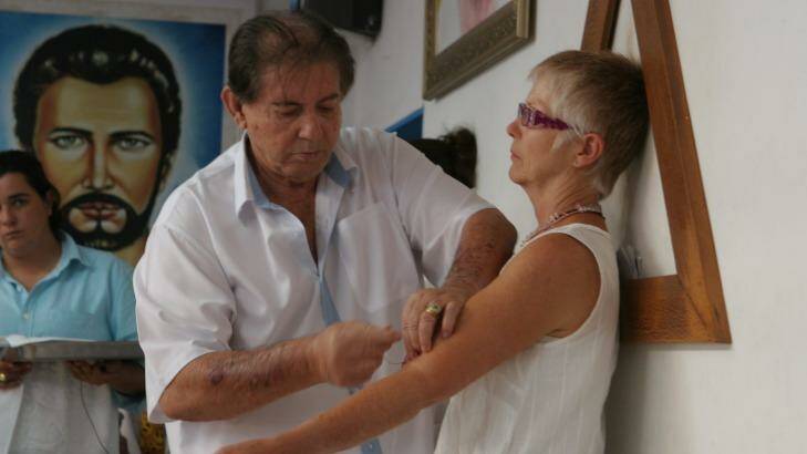 Joao de Deus operates on a woman's arm. Photo: Tim Elliot