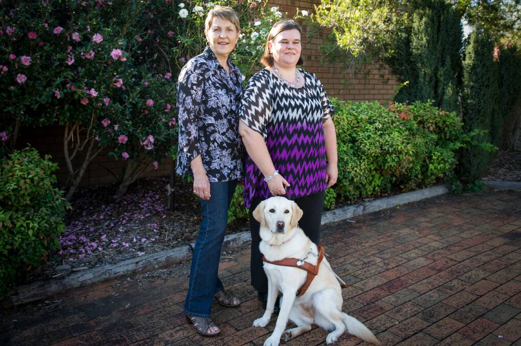 Oak Flats Progress Society is hosting a fund-raising morning tea to raise money for Guide Dogs NSW/ACT. President Helen Stewart and Samantha Noonan are pictured with Ms Noonan's guide dog, Sheba. Picture: ALBEY BOND