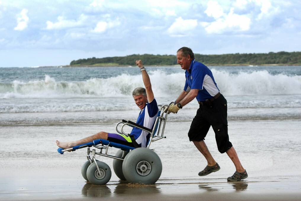 Len Snowden tries out the new Sandcruiser wheelchair at Shellharbour Beach, with assistance from Disabled Surfing Australia's Jim Bradley. Picture: SYLVIA LIBER