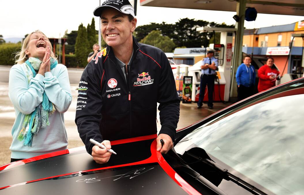 Red Bull Racing's Craig Lowndes signs the V8 Lowndes Commodore of Melbourne's Carolyn Weston. Picture: Scott Gelston