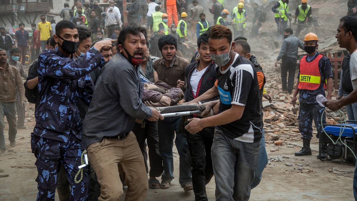 Emergency: Rescue workers carry an earthquake victim after Dharara tower collapsed in Kathmandu.  GETTY IMAGES