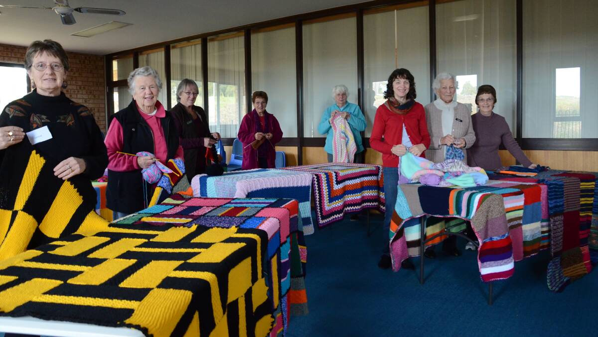 WINTER WARMERS: Wrap with Love Batemans Bay area knitters and crocheters (from left) Venise Hyland, Yvonne Hedrick, Jan Fazakerley, Inge Kumpus, Claire Lintern, Narelle Boehme, Edna Blayden and Robyn McDermott, with some of the wraps which have been created this year.