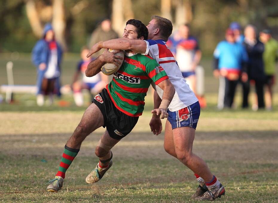 NEW HEIGHTS: Jamberoo’s Mark Asquith cops a tackle around the neck by Gerringong’s Reed Heagney. Photo: DAVID HALL 