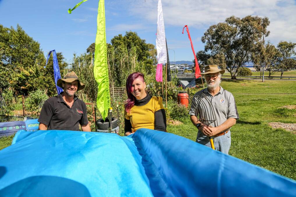 Barrack Heights Community Garden members Darren Bell, Tamar Stanford and Founding member Cliff Ball at the Barrack Heights community garden with their new flags. Picture: GEORGIA MATTS