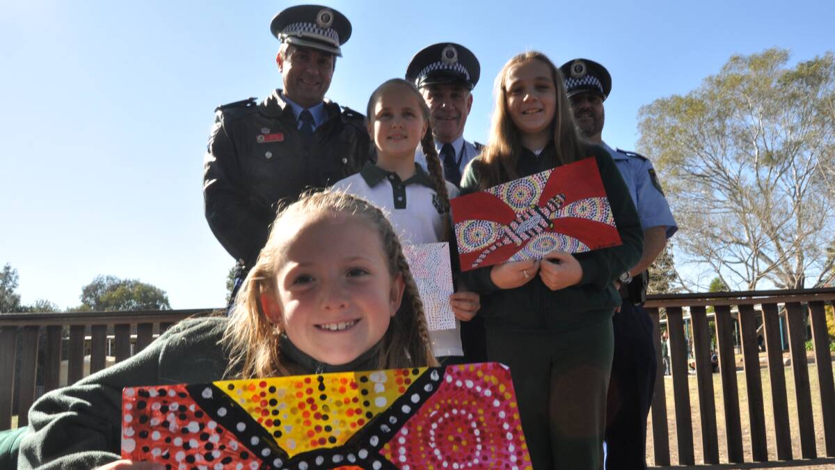 Winner of the Aboriginal Art Competition, Aliya Hazelton (front) from Albion Park Public School with other finalists Madison Jones-Morley and Keera Grimwood join the Lake Illawarra LAC Andrew Koutsoufis (acting superintendent), Mark Scott (acting sergeant) and Scott Burgess (senior constable. Picture Eliza Winkler