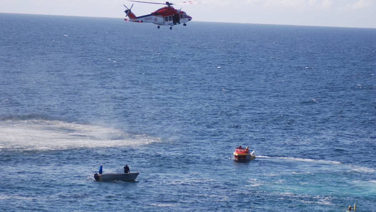 Ambulance helicopter and rescue craft circle the area where the fisherman was washed in at Blowhole Point.