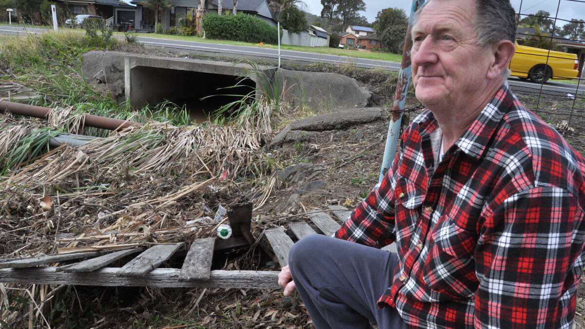 Albion Park resident Keith Hetherington at the water catchment out the front of his place that is blocked following the recent rains. Picture Eliza Winkler