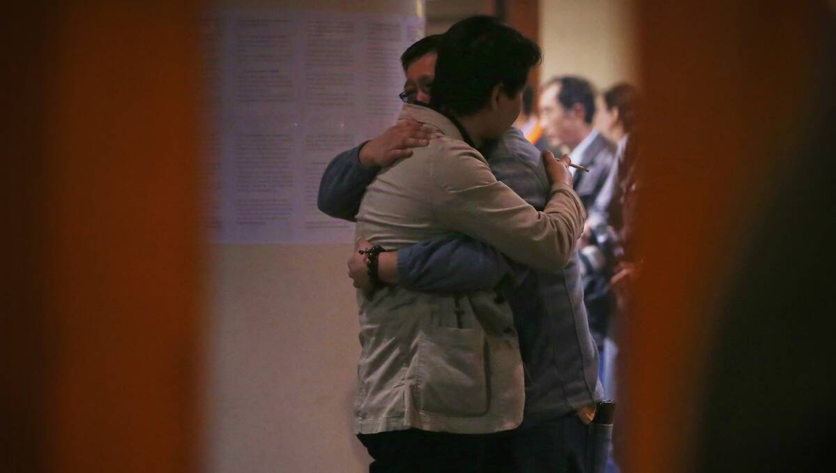 Chinese relatives of the passengers onboard Malaysia Airlines flight MH370 hug each other as they wait for the latest information in Beijing, China. Photo: Getty Images.