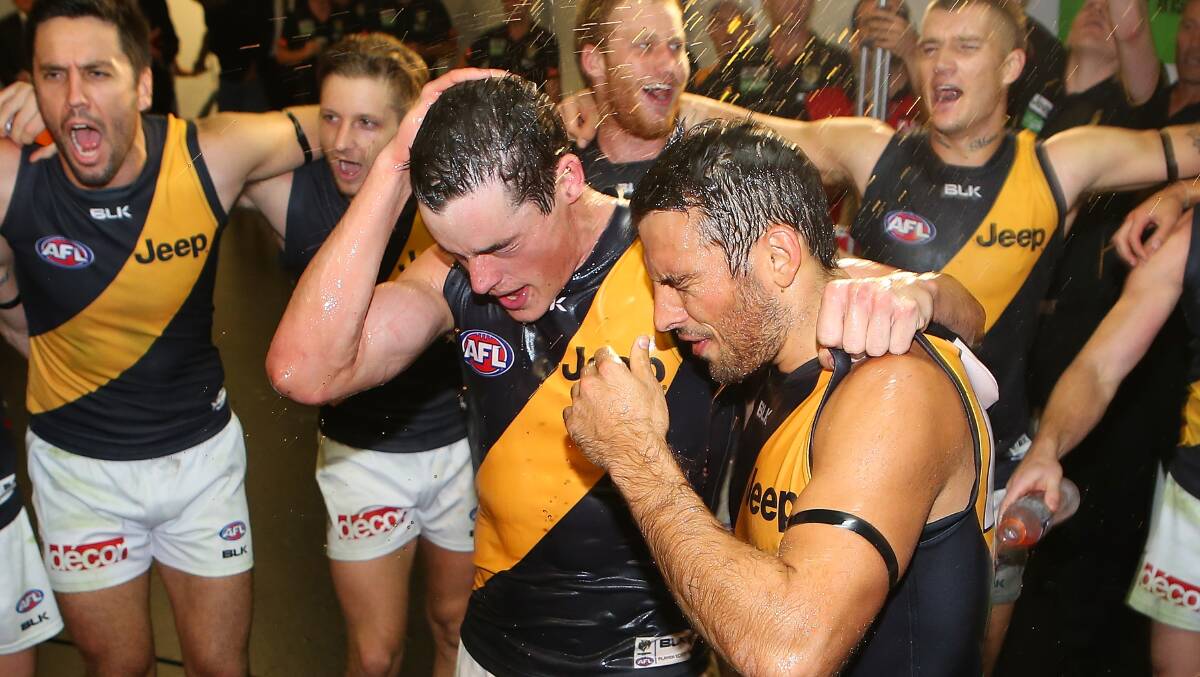 Nathan Gordon and Sam Lloyd of the Tigers sing the team song after winning the round five AFL match between the Brisbane Lions and the Richmond Tigers at The Gabba on April 17, 2014 in Brisbane, Australia. Photo: Chris Hyde/Getty Images.