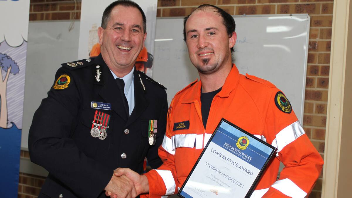 Acting Commissioner of NSW SES Jim Smith presents Stephen Middleton with a 10 year service certificate. Picture: DAVID HALL