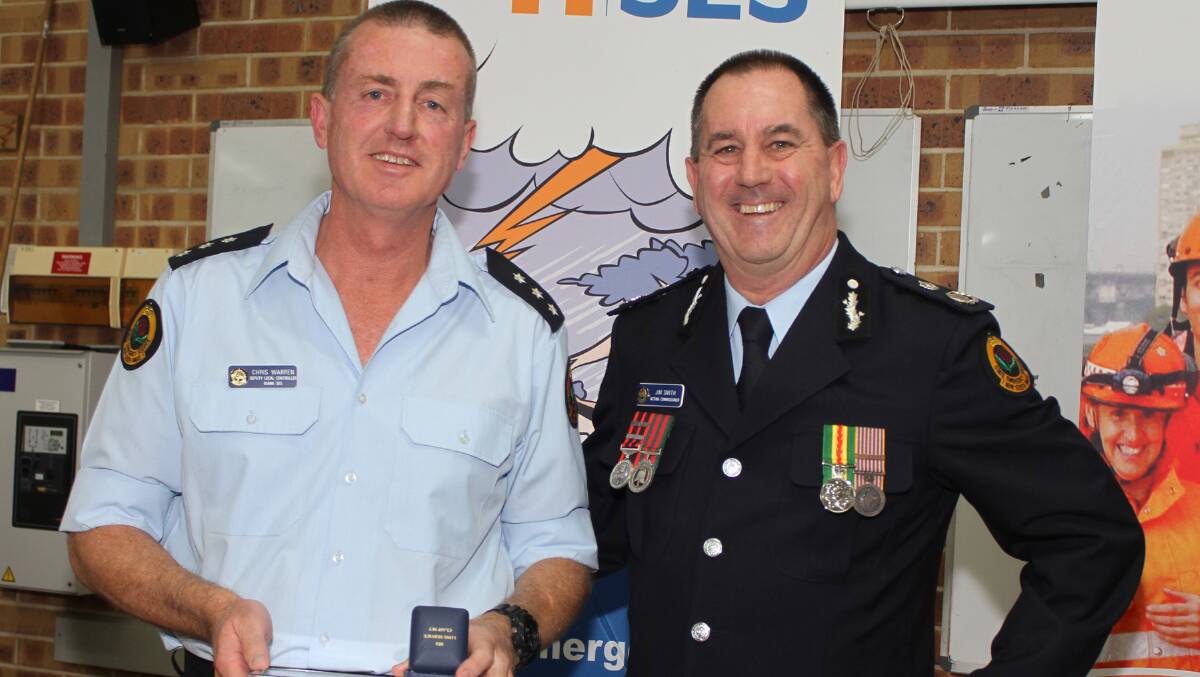 Kiama SES Member Chris Warren receives a certificate and pin from Acting Commissioner of NSW SES Jim Smith. Picture: DAVID HALL