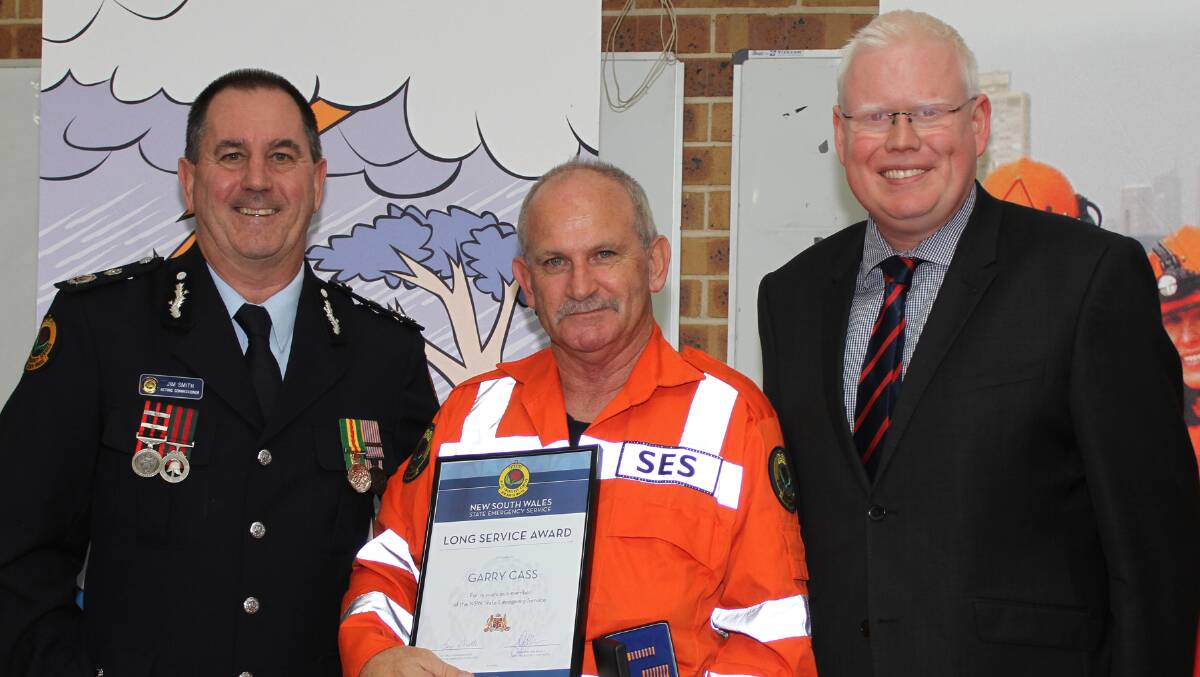 Acting Commissioner of NSW SES Jim Smith with Garry Cass, who received a 15-year certifictate and Member for Kiama Gareth Ward. Picture: DAVID HALL