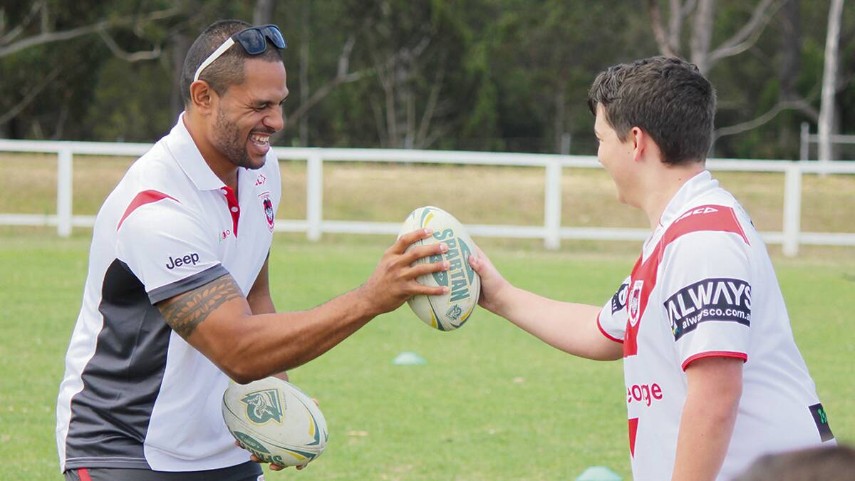PAMBULA: St George Illawarra Dragon Willie Mataka tests his grip against and eager local at a Pambula training clinic.  