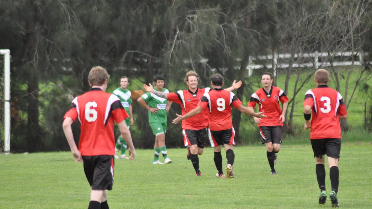 NOWRA: Shoalhaven United striker Shane Button celebrates with his team mates after netting his third goal in their 4-1 win over Huskisson at Lyrebird Park. Photo: PATRICK FAHY  