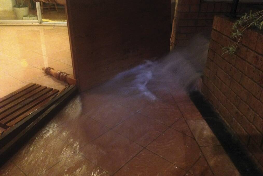 A deluge of water flowing into the back verandah of a house in Girrawheen Avenue, Kiama on Tuesday morning.