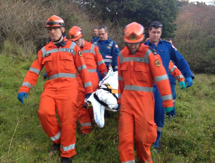 Kiama SES volunteers and paramedics carry a man who fell from his trail bike at Jamberoo on Saturday.  Picture KIAMA SES