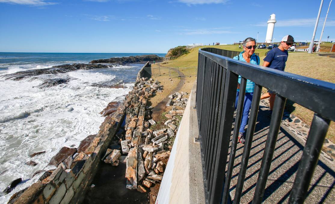 People walk past the destroyed sea wall at Wollongong's Flagstaff Hill. The wall, built in the 1880s, had stood the test of time and tides - until now.