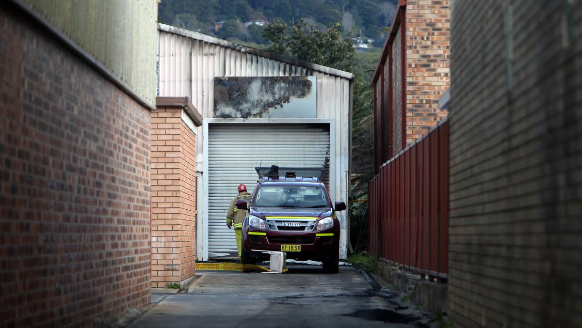 A Fire and Rescue NSW (FRNSW) investigator looks at what's left inside a shed on the Princes Highway at Fairy Meadow on Wednesday morning. Just hours earlier FRNSW crews from eigth Illawarra stations tackled the blaze, which is being treated as suspicious. Picture: Sylvia Liber