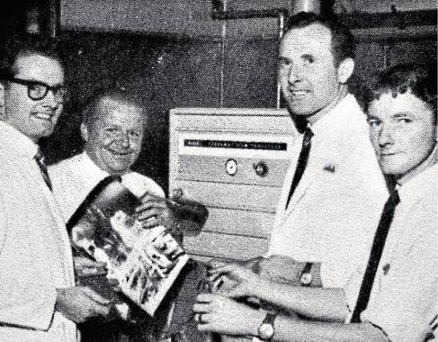 Kiama's Derek Davis (second from right) with the first prints of the 1969 moon landing.