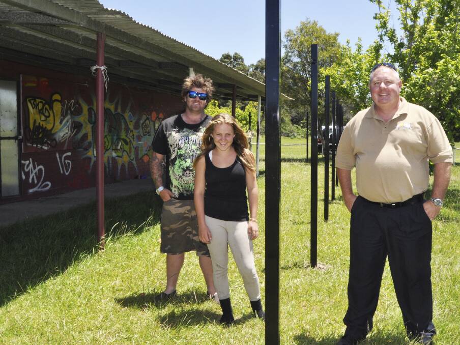 Stoney Range Pony Club president George Gibson and his 12-year-old daughter, Courtney, with Shellharbour councillor Paul Rankin with the partly erected fencing and the graffiti laden clubhouse. Picture: DAVID HALL