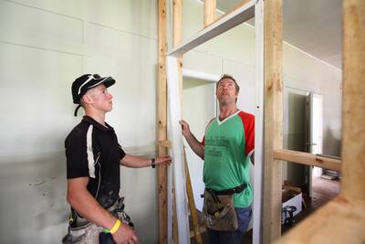 Jamberoo's Dennis Denwar (right) mounts a doorframe for a storeroom.