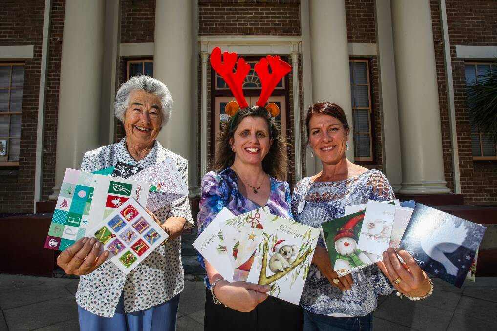 Kiama Red Cross branch members Gwen Hinchliffe, Heidi Smith and Vicki Robb with some of their wares. The 44th annual Combined Charities Christmas Card Shop opened last week. Picture: DYLAN ROBINSON