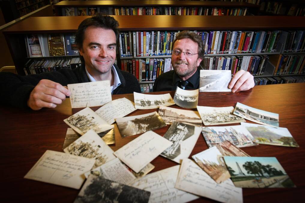 Kiama Library's Ken Donnellan and Michael Innes with some of the postcards Mr Innes's grandfather sent from France during World War I. Picture: DYLAN ROBINSON