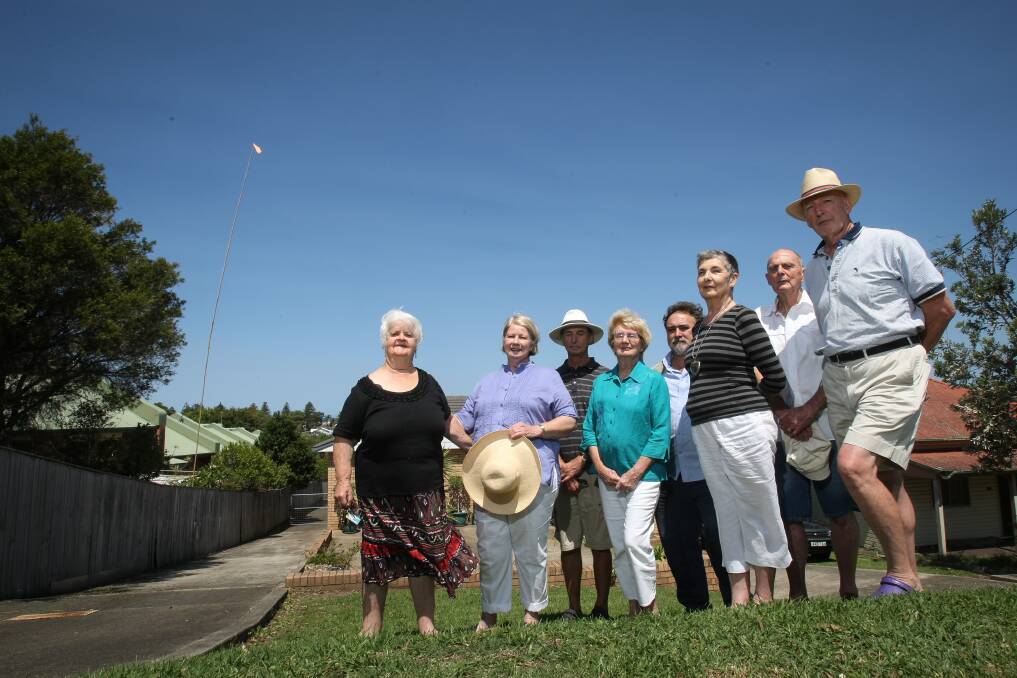 Iris Champion, Valerie McNamara, David Coughlan, Joy Hanrahan, Roman Wowk, Rosalind Howard, Rodney Howard and John Kelly are concerned about a 51-unit development proposed for Shoalhaven Street. The pole and flag to the left mark the height the building will reach. Picture: DYLAN ROBINSON