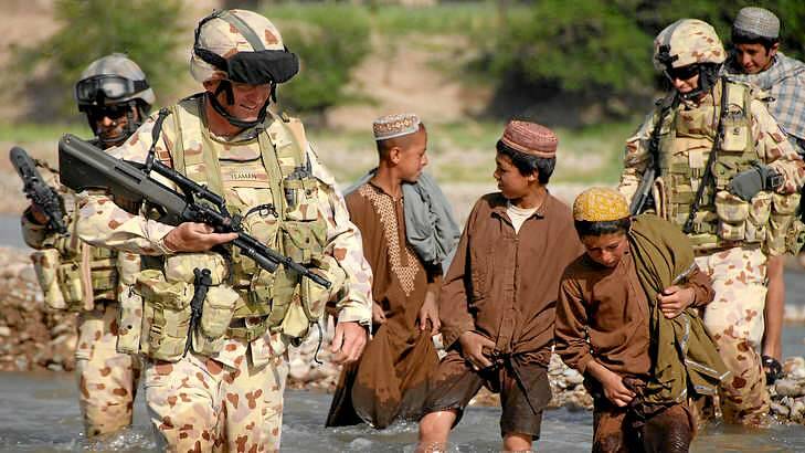 Lieutenant Colonel Stuart Yeaman is followed by enthusiastic Afghan boys. Photo: Corporal Neil Ruskin