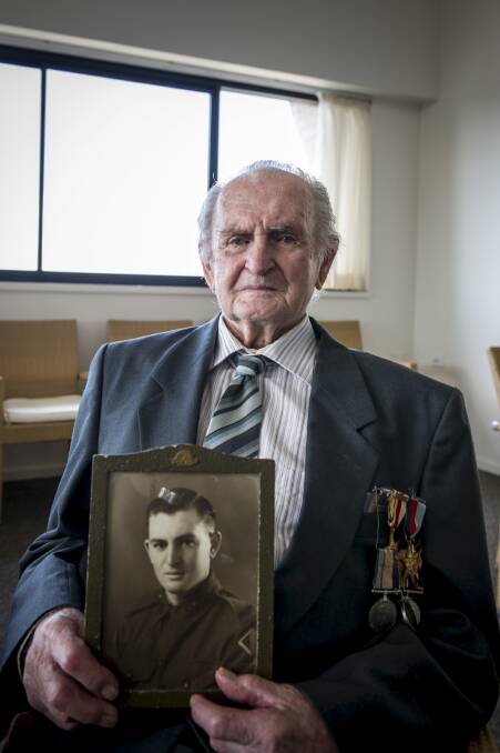 Kiama World War II veteran Geoff Honey with a photo of him before he headed off to serve his country. Picture: ALBEY BOND