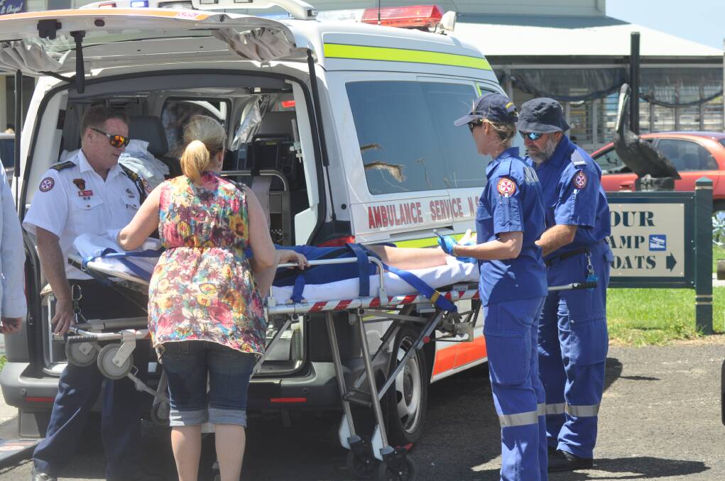 Paramedics wait for a doctor to arrive to remove a spear from the leg of a 12-year-old boy. Picture: DANIELLE CETINSKI