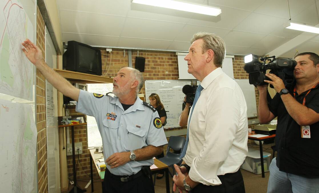 Kiama SES Deputy Controller John Wall shows NSW premier Barry O'Farrell a map of the damage done in Kiama on Sunday morning. 
