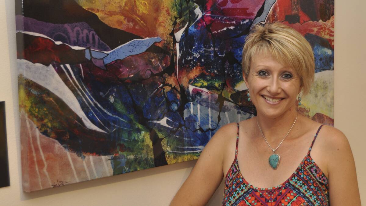 Kiama artsist Sharon Blair with one of the paintings now available at Freedom Furniture in Warrawong.