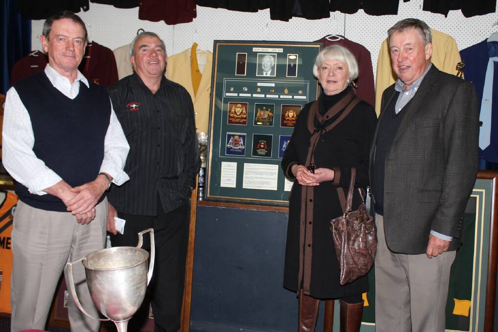 Children of the late South Coast Group 7 administrative legend Kevin Walsh with a display honouring him are Greg, Noel, Maria (Gardner) and Pat Walsh. Picture: DAVID HALL