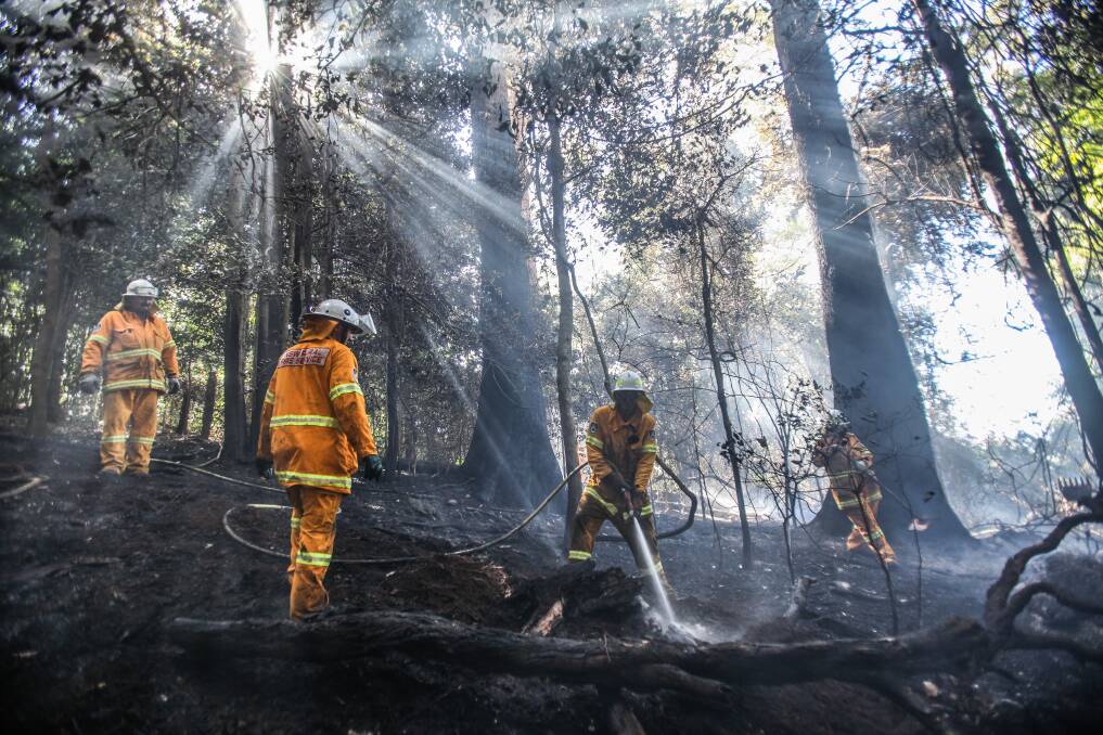 Jamberoo RFS members quickly mop up the remainder of last week's blaze. Picture: DYLAN ROBINSON