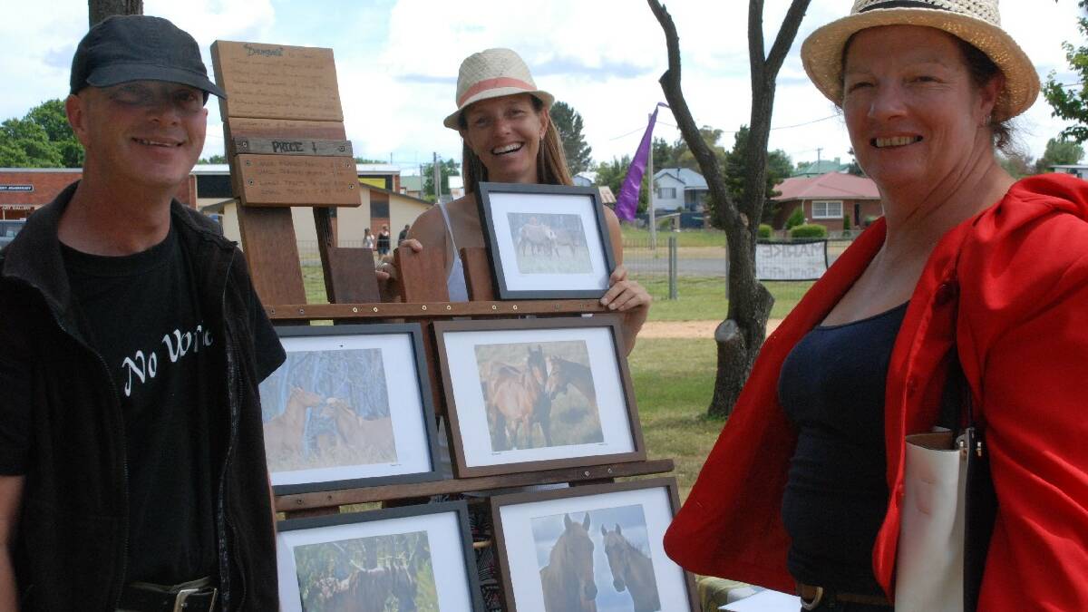  ADAMINABY: Admiring some framed photographs of brumbies are locals Adrian Cornish, Mel Hale and Annie Robinson at the Adaminaby Markets which attracted a good crowd of tourists at the weekend.