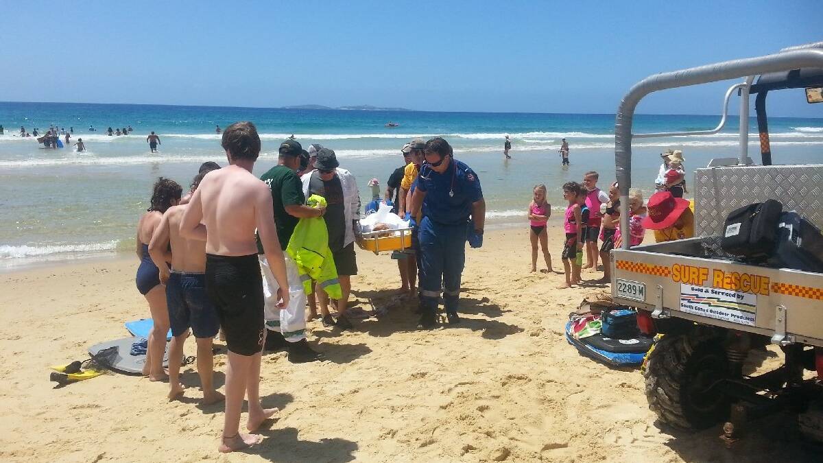 NAROOMA: Ambulance paramedics, VRA rescue squad members and surf patrol members start to carry the stricken young woman up Narooma surf beach after she lost consciousness in the surf on Sunday. Thankfully she was swimming between the flags and so received immediate attention.