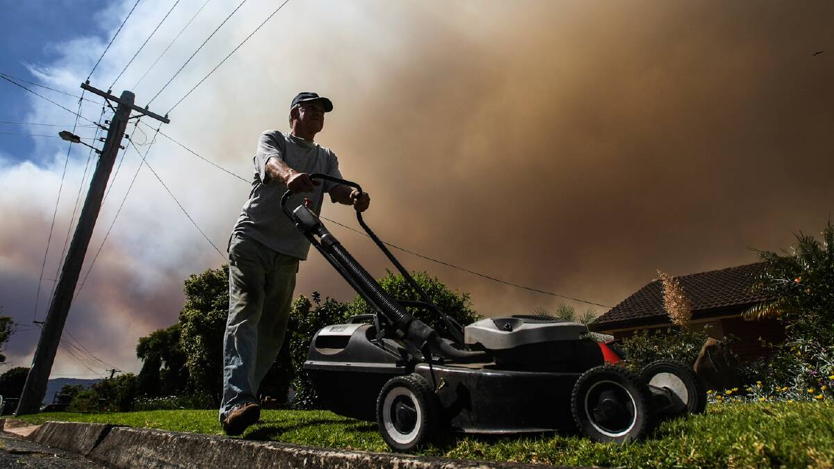 Bushfire smoke covered the Wollongong and Lake Illawarra regions in a thick blanket. Mt Warrigal's Ernie Kedrere mowing his lawn under a dark sky.  Picture: DYLAN ROBINSON