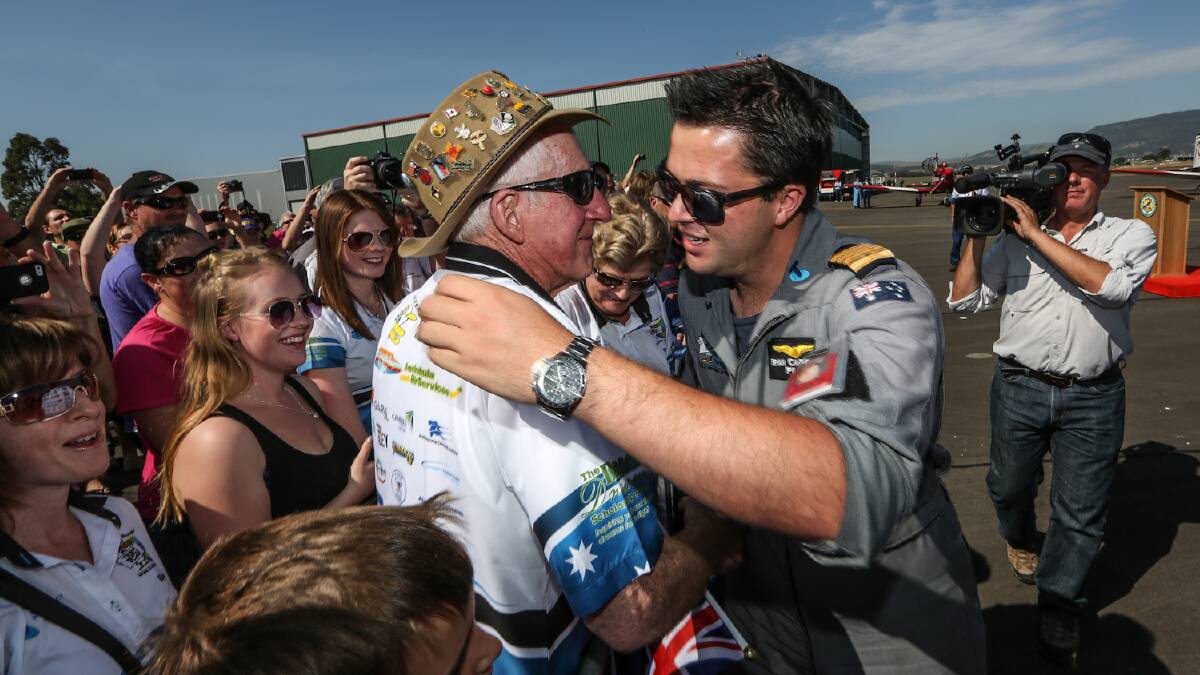 Ryan Campbell, 17, greets his grandfather at Albion Park Airport after flying around the world. Picture: DYLAN ROBINSON