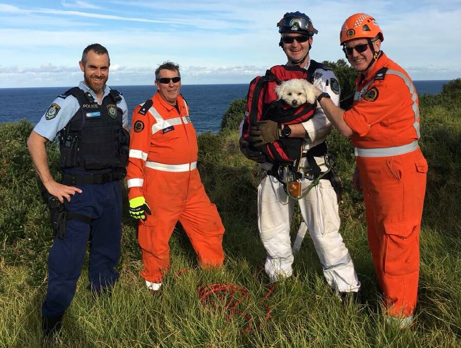 ALL SMILES: MacGregor with his rescuers. Photo: Kiama SES.