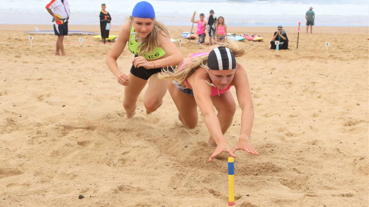 STIFF COMPETITION: Mollymook's Karla Jones dives to win gold in the under 15 girls beach flags at Gerringong on Saturday. Photo: KEN BANKS