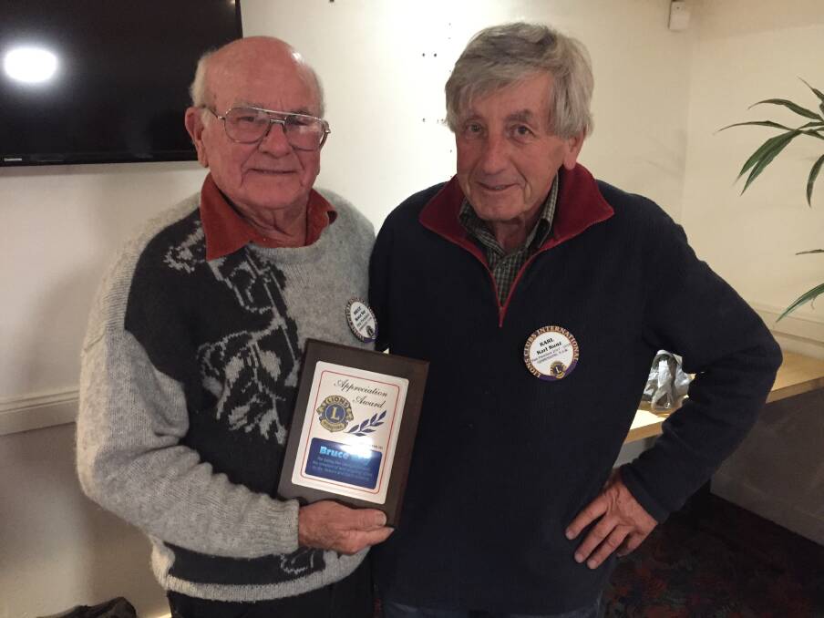 The photo shows Bruce Ray (left) with past Lions President Karl Kunz (right) receiving his award.