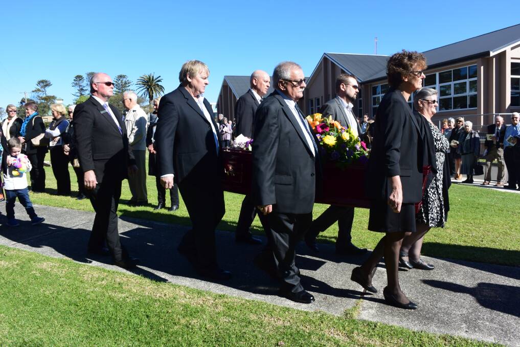 Family members carry the casket through a guard of honour at the church on Friday.