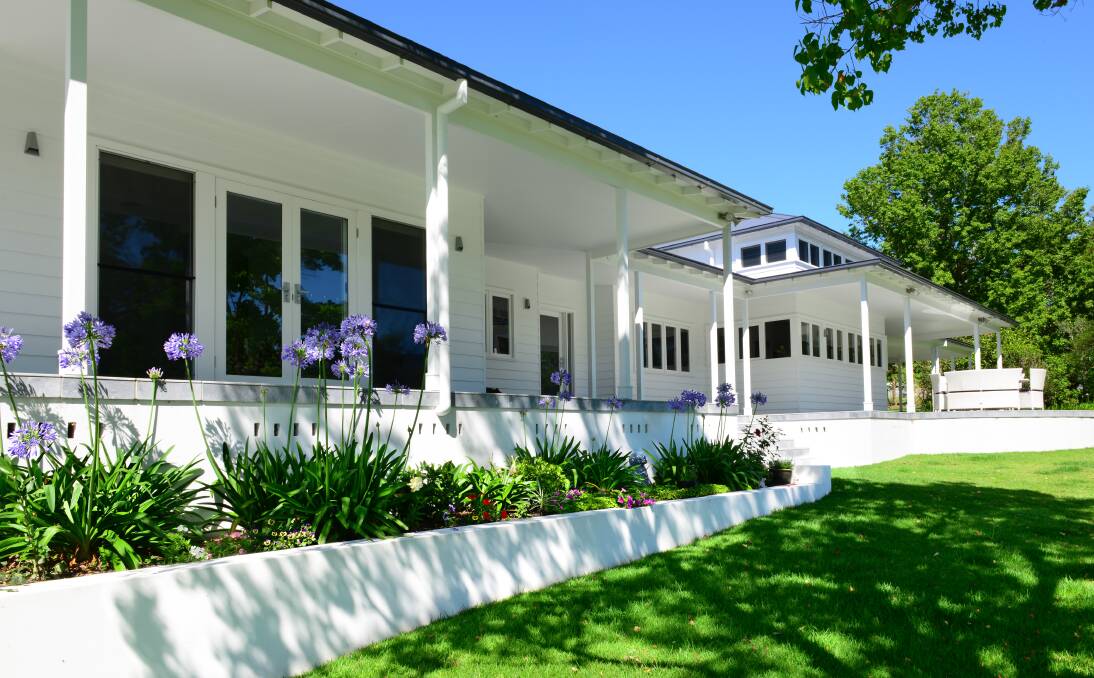 Two acres of lawn, well-placed garden beds, citrus trees and feature trees wrap around the home. Photo: Supplied