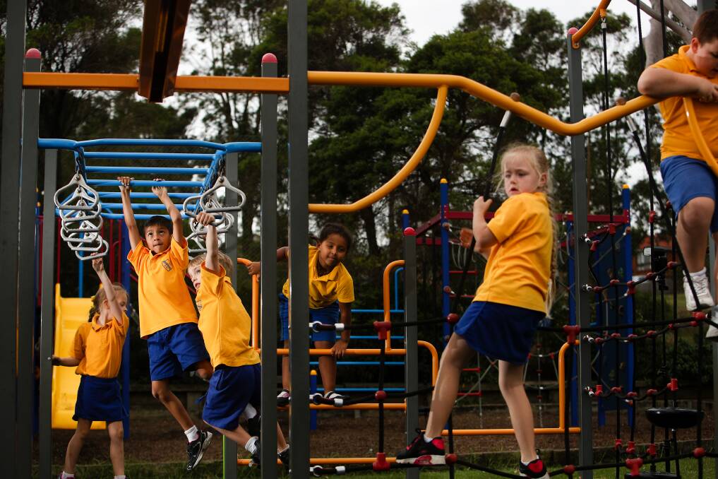 Lake Heights Public School students playing on the school's playground equipment. Seven Illawarra schools will be open to the public during the winter holidays. Picture: Adam McLean